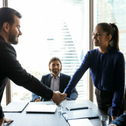 Man and woman shaking hands in a meeting