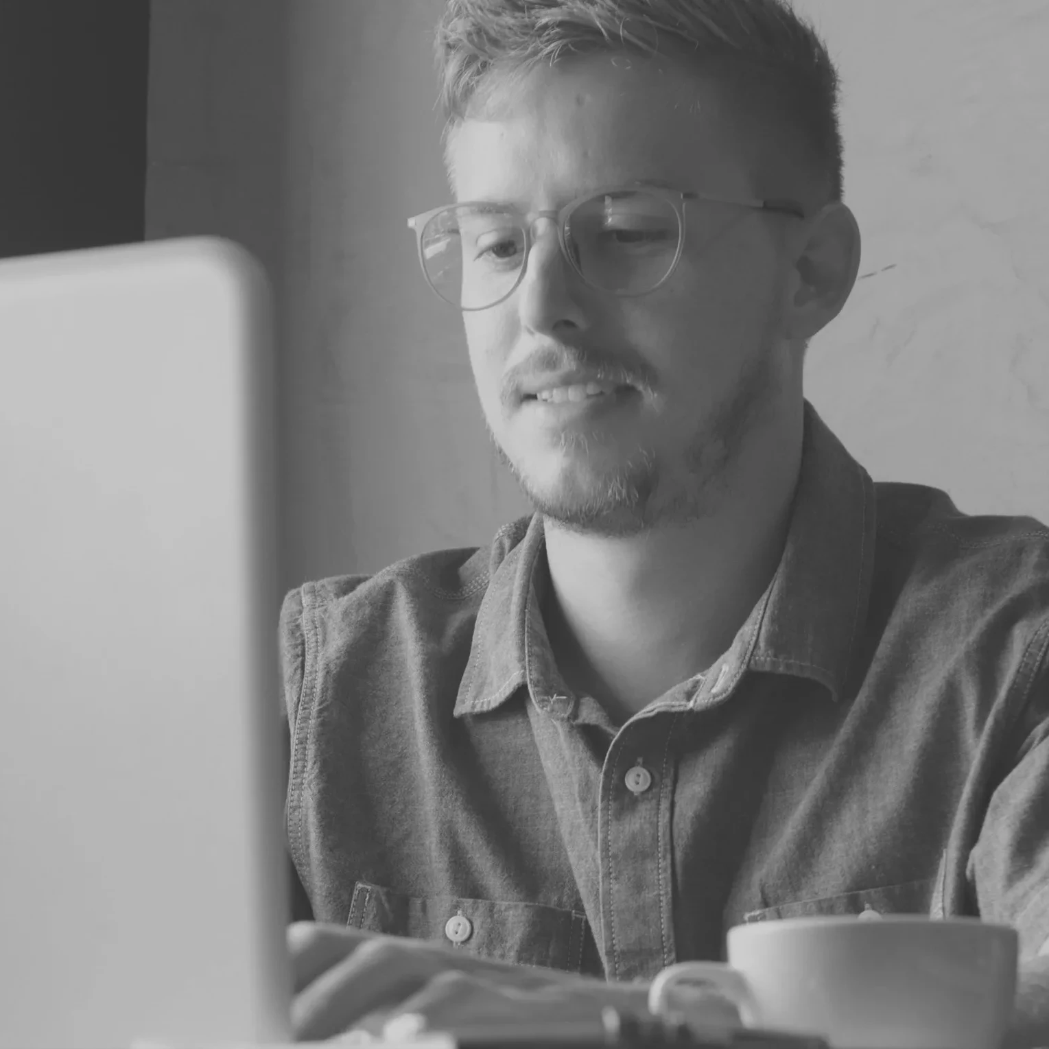 Man writing CV on laptop at home